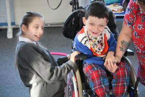 smiling boy in wheelchair with girl