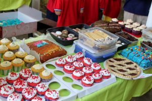 table filled with colourful cakes at school event