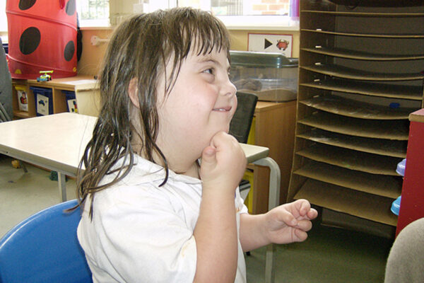 girl with down's syndrome using sign language in class