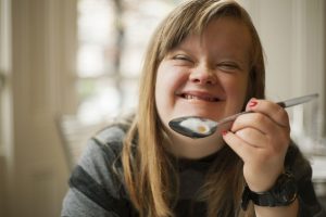 young woman wiht down's syndrome eating cereal