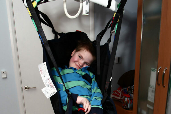 smiling disabled boy in hoist