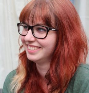 Young woman with long red hair and glasses