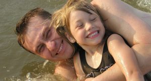 dad and daughter laughing in sea