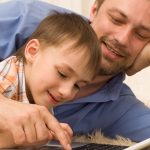 dad searching on computer with son