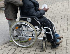 person in a wheelchair being pushed by another person