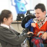 happy boy in wheelchair with girl