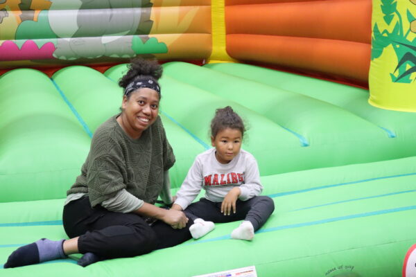 Mum and daughter sit on bouncy castle