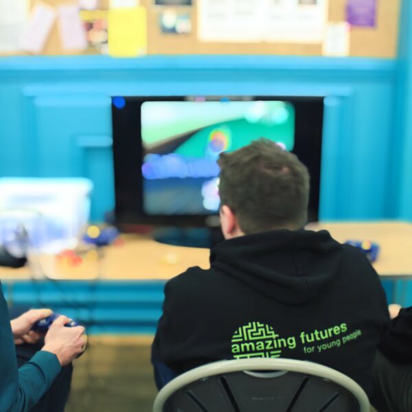 Young men back view playing computer games at Amazing Futures group