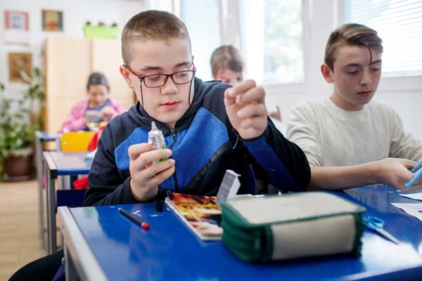 Two older boys doing a craft activity in a classroom